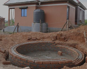 A newly built latrine and rainwater tank at a rural homestead