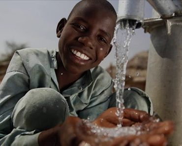 A smiling child holding fresh water